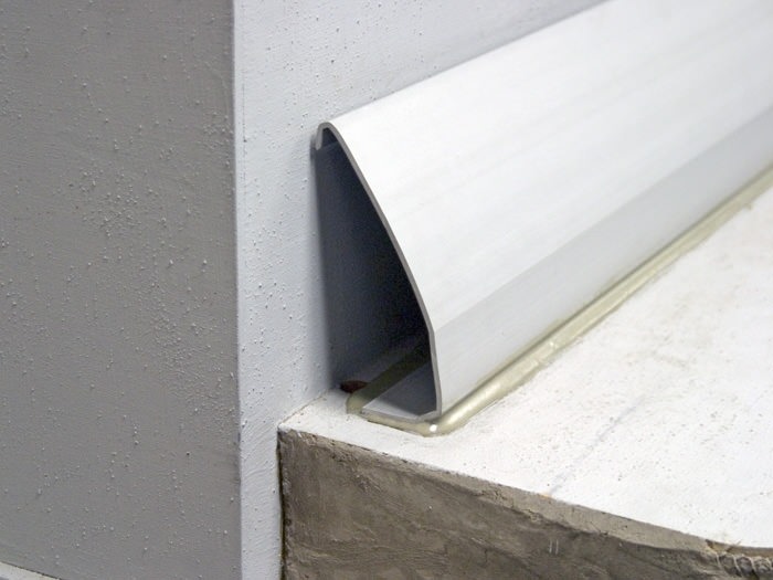 Cutaway diagram of a baseboard basement drainage system
